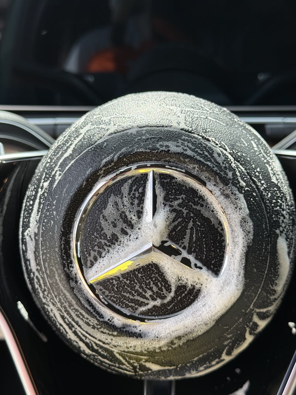 Foam wash over the Mercedes star badge during mobile detailing in Edmond OK